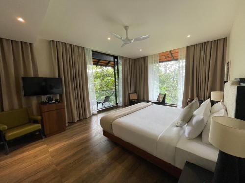 维特利Flora Vythiri Resort的酒店客房设有一张大床和一台电视。