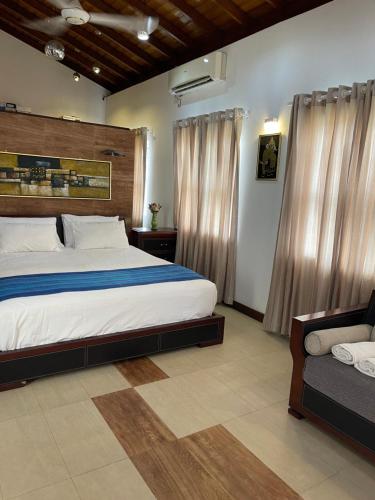 BoralesgamuwaAtrium Leisure的一间卧室配有一张大床和一张沙发