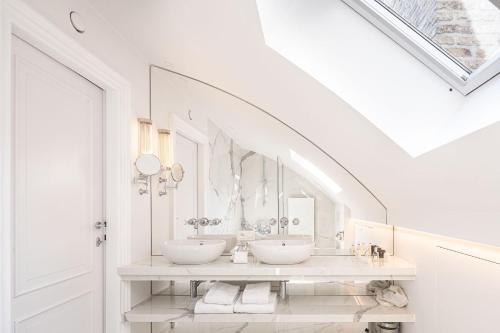 布鲁日德图雷恩酒店 - 世界小型豪华酒店的白色的浴室设有两个盥洗盆和镜子