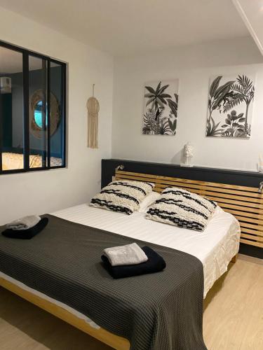 圣吉尔莱班Centre & plage - T2 cosy avec terrasse & jardin的一间卧室配有一张大床,提供黑白枕头