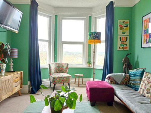 金斯布里奇Unique 2-bedroom Coastal Town Retreat的客厅设有绿色的墙壁和沙发