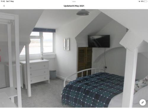克里基厄斯Beachside holiday house的一间卧室设有一张床、一台电视和一个窗口。