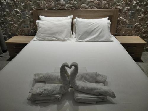 埃尔米奥尼Estia - Brand new apartment in Ermioni Village的床上用毛巾制成的两天鹅