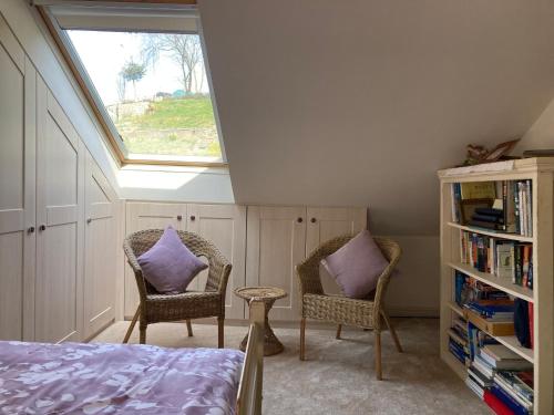 KentCosy twin room with private bathroom的一间卧室设有天窗和两把椅子,配有紫色枕头