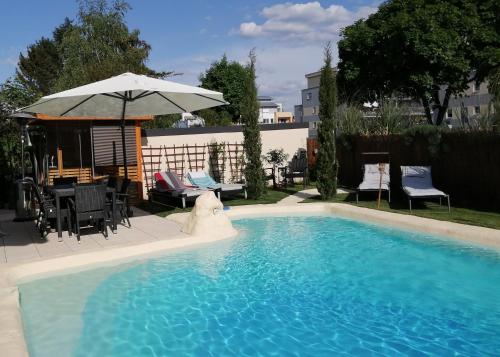 洛尔施Belle Etage geräumige Ferienwohnung mit Pool und Sauna的一个带遮阳伞和桌椅的游泳池