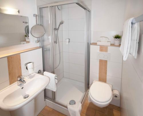 施林根格拉夫旅馆的带淋浴、卫生间和盥洗盆的浴室