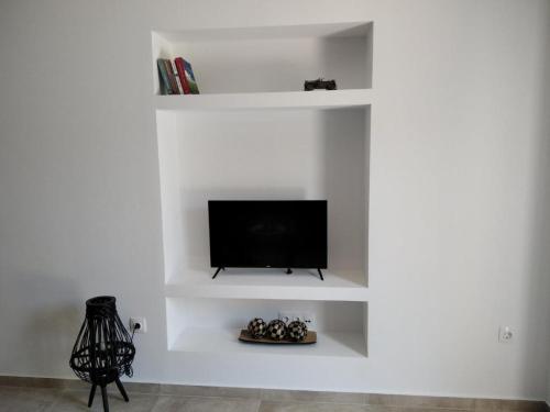 埃尔米奥尼Armonia - Brand new apartment in Ermioni Village的客厅配有白色架子上的电视