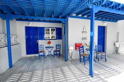 佩里萨Lunar Santorini Hotel的客厅设有蓝色横梁和桌椅