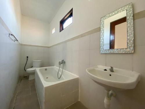 八丹拜庞多敏巴旅馆的一间带水槽、卫生间和镜子的浴室