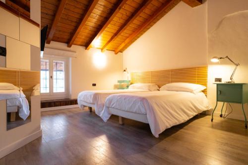 曼德洛德拉廖Locanda Alberti的一间卧室设有两张床和木制天花板