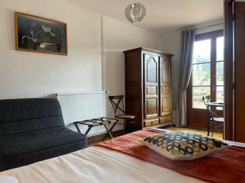 鲁贡Auberge du Point Sublime的一间卧室配有一张床、一张沙发和一个窗口