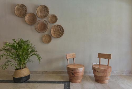 赫尔格达The Bay Hotel Hurghada Marina的墙上有两把椅子和篮子,墙上有植物