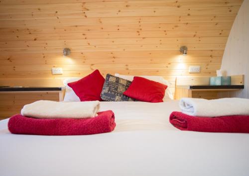 GreenheadHadrian's Holiday Lodges的一张带红色和白色枕头的床