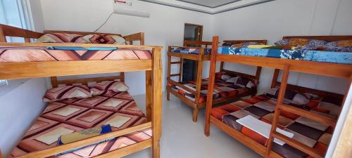 BulalaJCALM Beach resort的一间房间,设有三张双层床