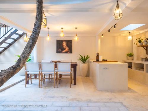 塞米亚克The Oberoi Luxury Villas Seminyak的厨房以及带桌椅的用餐室。