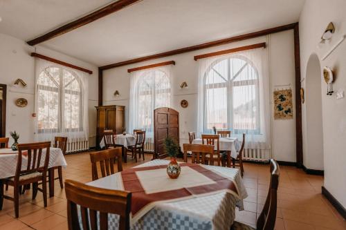 格奥尔盖尼Pensiune și Camping Patru - Gheorgheni的用餐室设有桌椅和窗户。