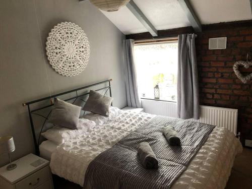 BebingtonCosy Rustic 3 bed cottage, great train links的一间卧室,配有一张床,上面有两双鞋