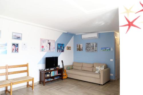 伊索拉戴里费米尼Casa Piano Ponente的客厅拥有蓝色的墙壁和沙发