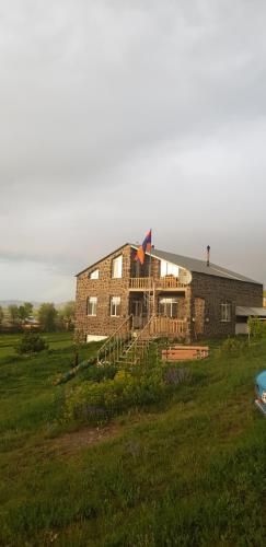 ArtsvakarGuest House AREVIK的田野上的砖房,上面放风筝