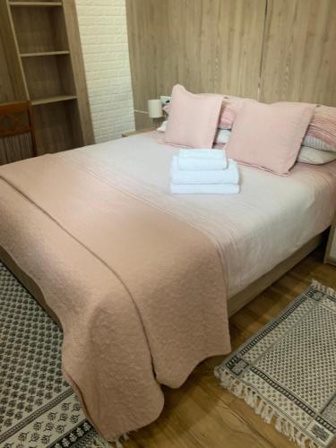拉腊什Larache city的一张带粉红色枕头的床和毛巾