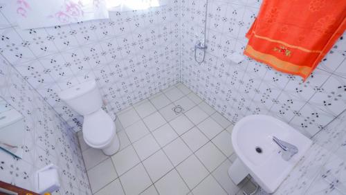 基加利Da Vinci House的白色的浴室设有卫生间和水槽。