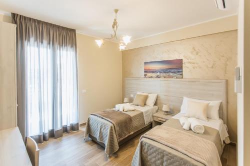 阿奇卡斯泰洛Oasi Perla Del Mare Rooms的酒店客房设有两张床和窗户。