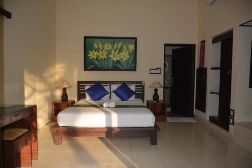 甘地达萨赛格瑞湾哥比奇旅馆的一间卧室配有一张带蓝色枕头的大床