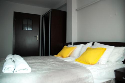 米科瓦伊基Słoneczne Tarasy的一间卧室配有一张带黄色和白色枕头的大床