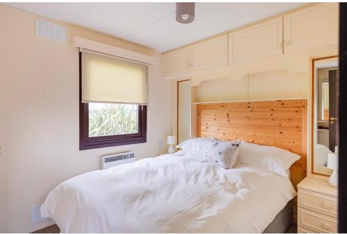 斯特兰拉尔Lodge Cabin with Fabulous Views - Farm Holiday的卧室配有一张大白色床和窗户