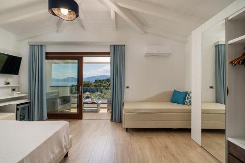 卡拉古诺内I Ginepri Hotel的一间卧室配有一张床、一张沙发和一个窗口