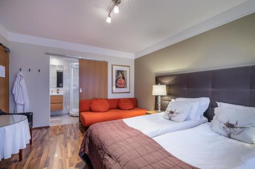 雷克雅未克Snorri's Guesthouse的一间卧室配有一张床和一个橙色的沙发