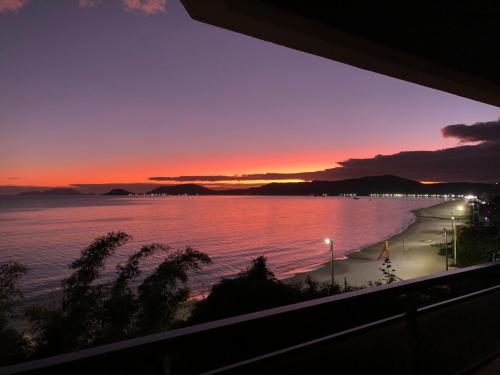 弗洛里亚诺波利斯Cobertura frente ao mar的阳台享有日落海滩的景致。