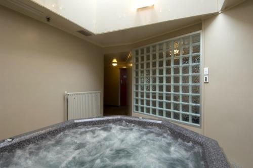 因弗卡吉尔阿斯科特公园酒店的一个带窗户的客房内的按摩浴缸