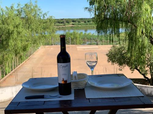 亚松森CostaMansa House, a orillas del Rio Paraguay的一张桌子上坐着一瓶葡萄酒和一杯