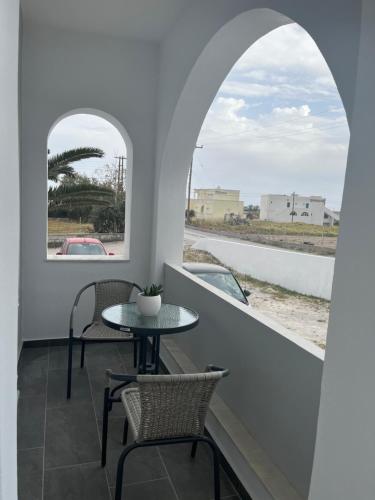 佩里沃罗Ether的阳台配有桌椅和窗户。