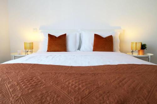 阿尔布费拉Albufeira Central Apartment, 10 mins walk to beach的一间卧室配有一张带红色枕头的大床