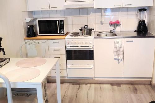 波里Viihtyisä yksiö Porissa的厨房配有白色橱柜和炉灶烤箱。