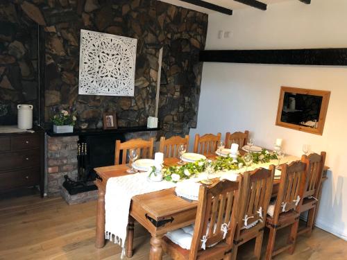 BebingtonCosy Rustic 3 bed cottage, great train links的一间设有桌椅和石墙的用餐室