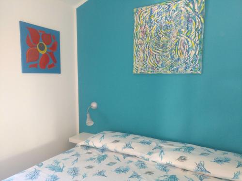 帕尔蒂尼科Sunsea的卧室配有一张床,墙上挂有绘画作品