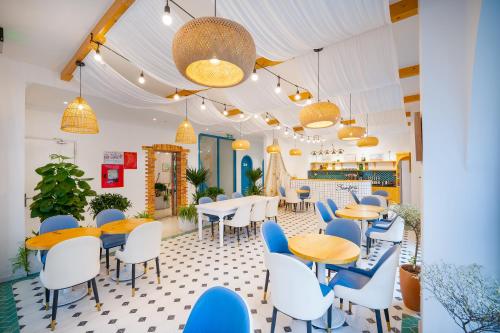 岘港Santori Hotel And Spa的餐厅设有蓝色和白色的椅子和桌子