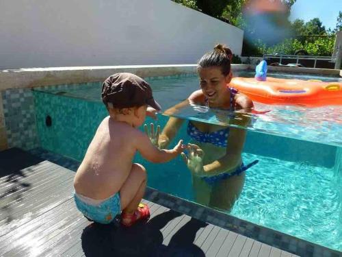 普罗旺斯艾克斯Très belle maison avec piscine , proche centre ville - Aix en Provence的两个孩子在游泳池玩耍