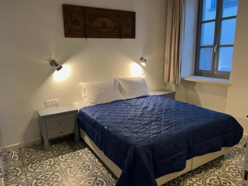 伊兹拉Mercato Vecchio House的一间卧室配有一张带蓝色棉被的床
