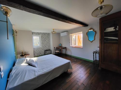 Taurignan-VieuxGîte PRAT NAOU - PYRENNEES ARIEGEOISES的卧室配有白色的床,铺有木地板
