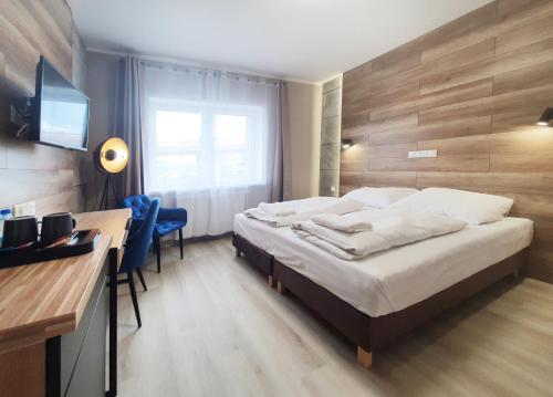 格丁尼亚Kamienica Morska Gdynia的酒店客房配有一张床和一张带电脑的书桌
