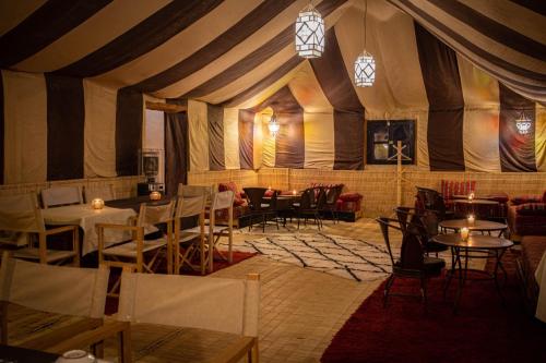 姆哈米德Desert Luxury Camp的帐篷内带桌椅的用餐室