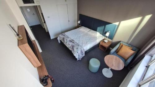 悉尼Chatswood Hotel的卧室享有高空美景,配有一张床和一把椅子
