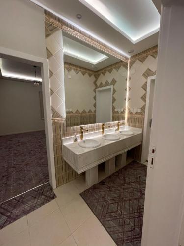 艾卜哈القمة العالية的一间带两个盥洗盆和大镜子的浴室