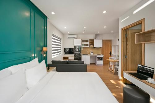 岘港Dolphin Hotel and Apartment的一间带白色大床的卧室和一间厨房
