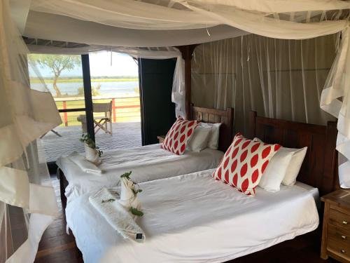 MafutaBubezi Camp的带阳台的客房内的两张床