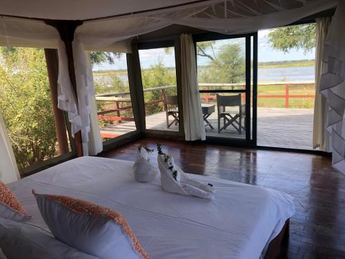 MafutaBubezi Camp的卧室配有白色床,享有水景